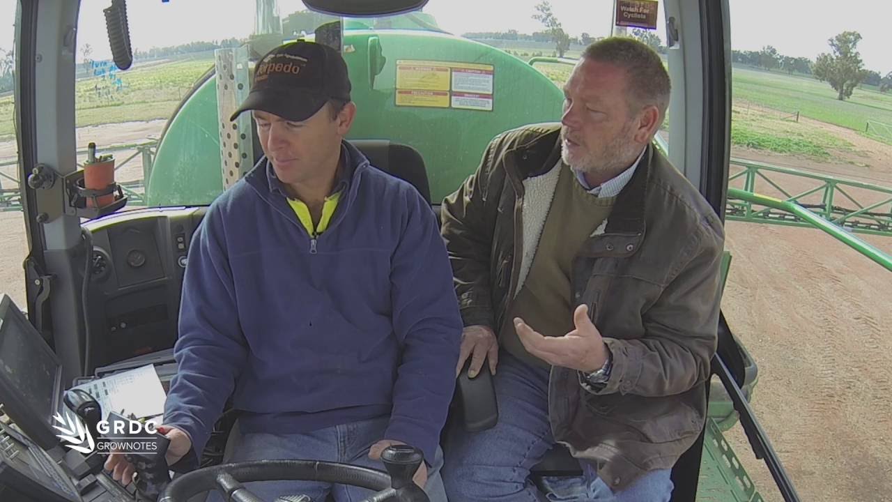 2 men sitting on a tractor talking