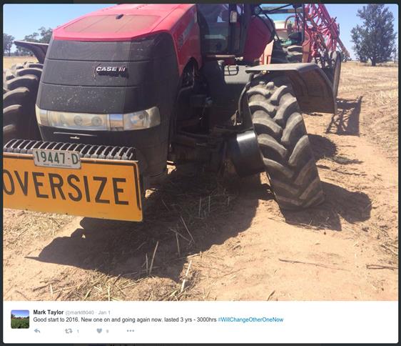 A screenshot of a twitter post showing a tractor with an oversize sign on the front